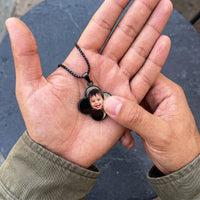 Thumbnail for Thumb warming the black clover pendant: the hidden photo appears under the thumb while the rest stays black | SKU: TPH-CLVN-BLACK