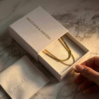 Thumbnail for The Double Luxe necklace by Brother & Sisters in elegant packaging, showcasing sophisticated double-chain design.
