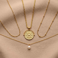 Thumbnail for Golden Sun Necklace featuring a textured sun medallion pendant from Brother & Sisters, layered with classic gold chains.