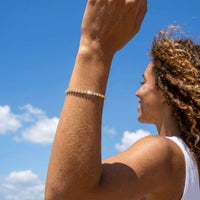 Thumbnail for Woman wearing a Tennis Bracelet by Brother & Sisters, enjoying a sunny outdoor day with a glamorous sparkle.