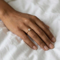 Thumbnail for Crystal Flower Ring on a hand, featuring a miniature four-leaf crystal flower and delicate band by Brother & Sisters.