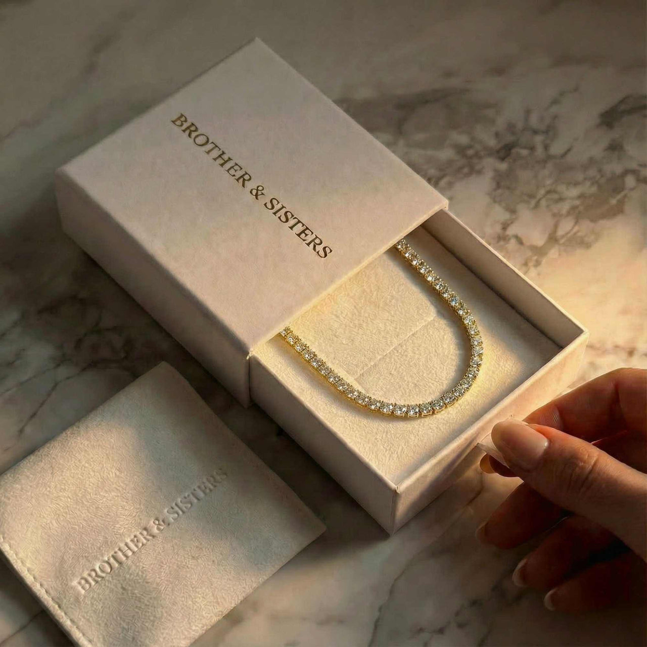 Isolde Tennis Necklace displayed in a Brother & Sisters box, showcasing its 3mm diamond simulants and 18K gold.