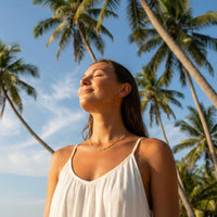 Thumbnail for Woman wearing a Rainbow Choker by Brother & Sisters under palm trees, enjoying sunny outdoors.