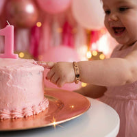 Thumbnail for Infant Bracelet worn by a joyful baby reaching for a pink birthday cake, celebrating their first birthday with Brother & Sisters.
