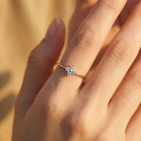 Thumbnail for Crystal Flower Ring on a delicate hand featuring a four-leaf zirconia flower, by Brother & Sisters.