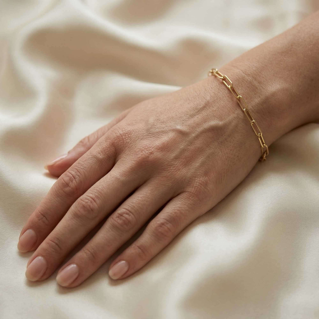 Hand wearing a Paperclip Chain Bracelet by Brother & Sisters, featuring simple links and premium stainless steel with gold finish.