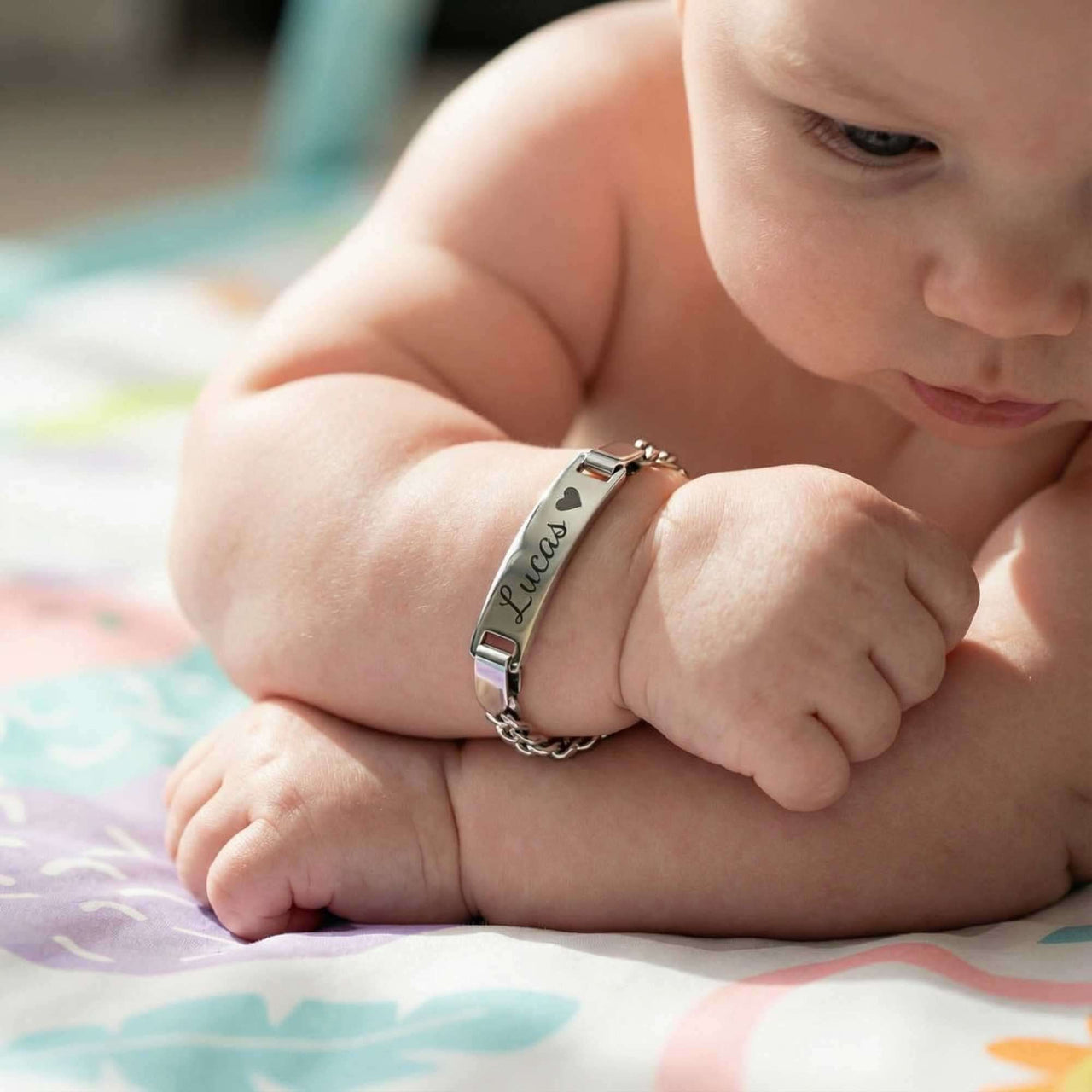 Infant Bracelet on a baby's wrist featuring personalized engraving and charming design by Brother & Sisters.