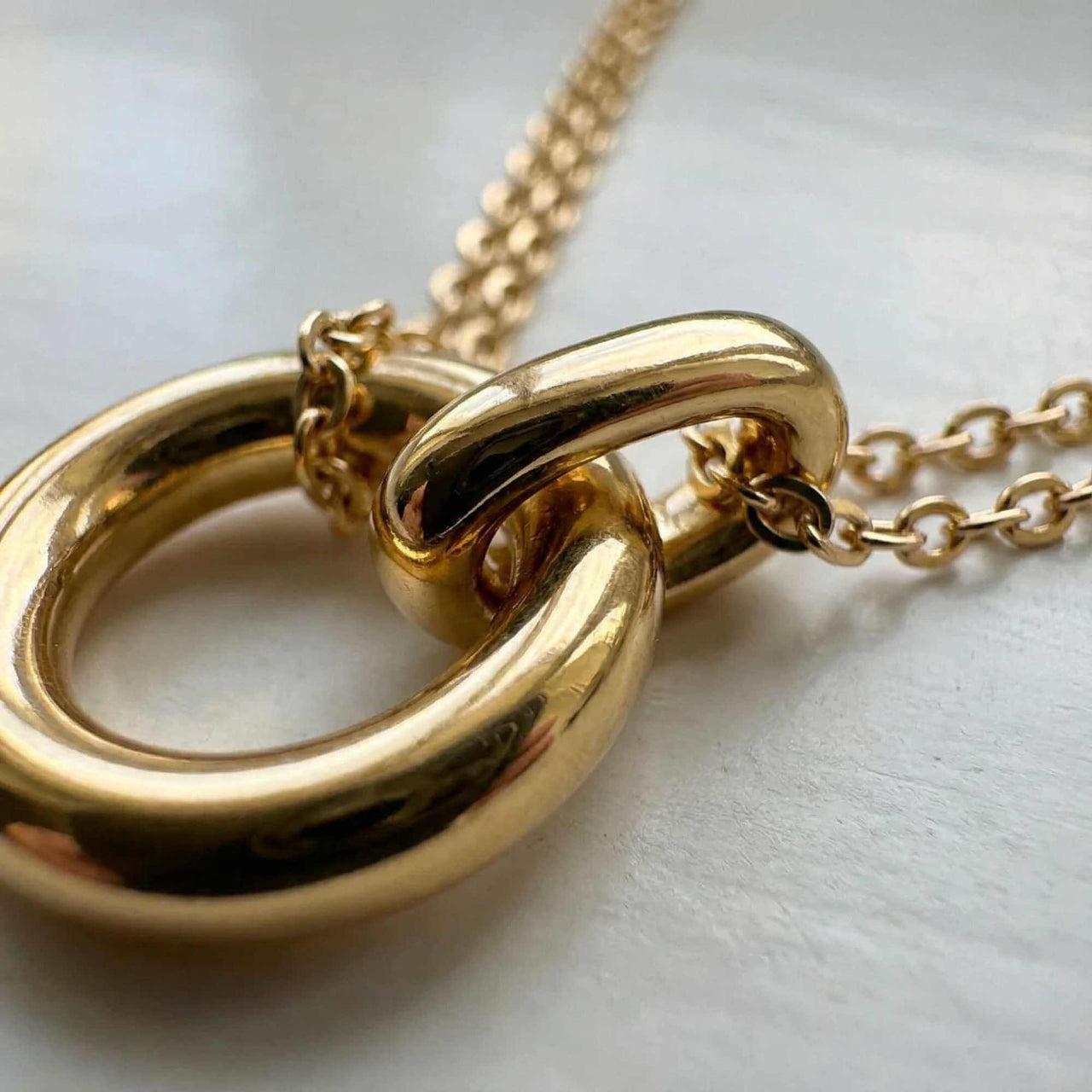 The Eternal Link necklace by Brother & Sisters features a double-layer design with interlocking gold circle pendants.