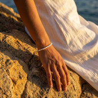 Thumbnail for Freshwater Pearl Bracelet worn on a hand resting on rocks, handcrafted by Brother & Sisters, showcasing unique pearls.