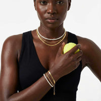 Thumbnail for Calvi Rope Chain Bracelet worn with layered necklaces and holding a tennis ball, by Brother & Sisters.