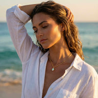 Thumbnail for Opal Pendant Necklace worn by model near beach, highlighting its AAA-grade opal and gold prongs by Brother & Sisters.