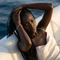 Thumbnail for Model showcasing the Double White Bracelet by Brother & Sisters with delicate white enamel beads and gold links.