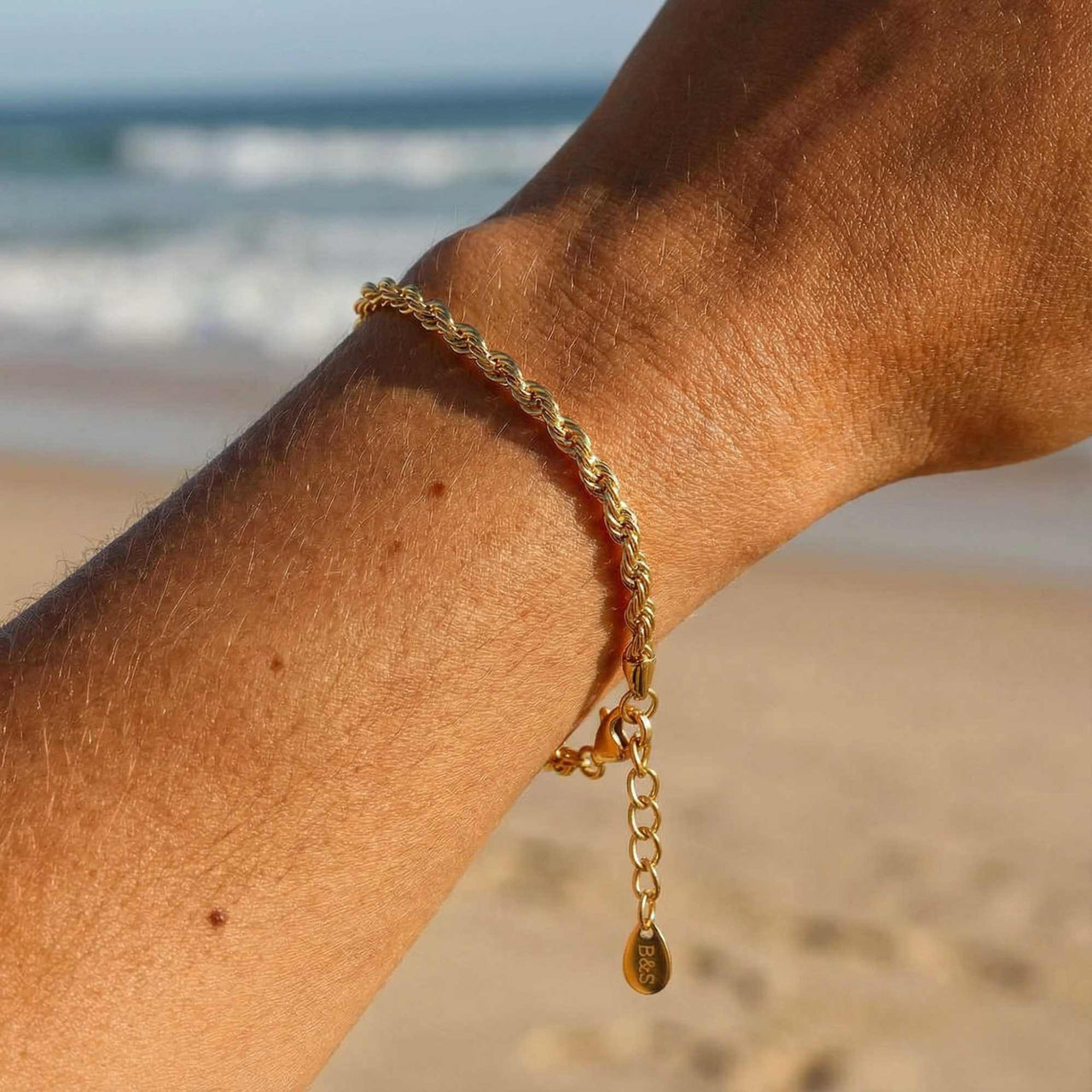 Calvi Rope Chain Bracelet on a wrist, showcasing twisted links and 18K gold PVD finish by Brother & Sisters.