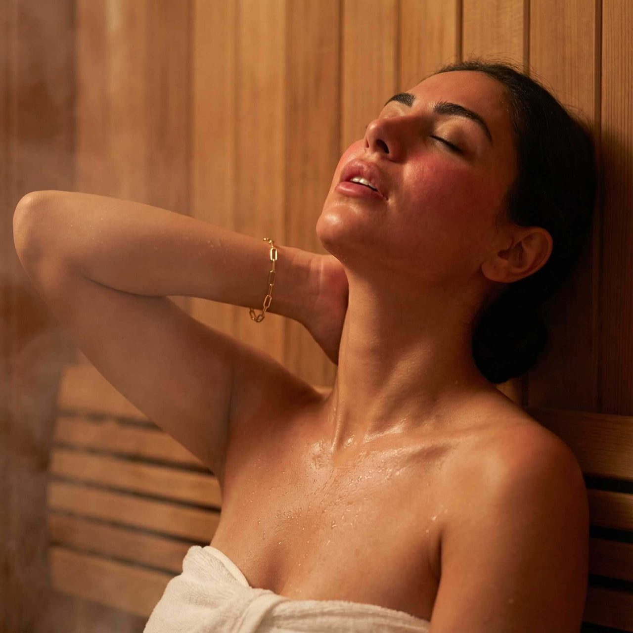 Woman enjoying a steam sauna wearing a Paperclip Chain Bracelet by Brother & Sisters, showcasing elegant design and style.