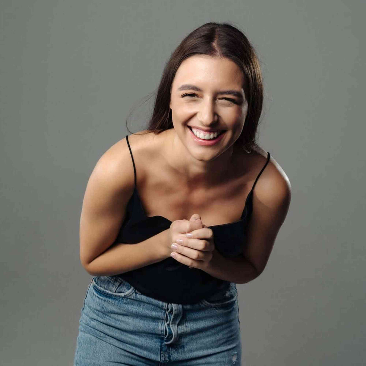 Smiling woman in casual attire showcasing happiness and joy, perfect for lifestyle or fashion imagery.