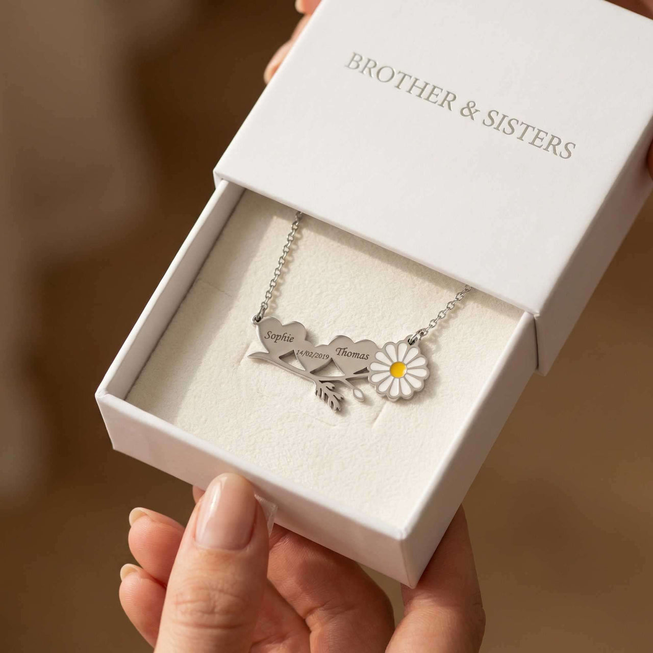 Daisy Name Necklace in gift box by Brother & Sisters with engraved names and enamel daisy design.