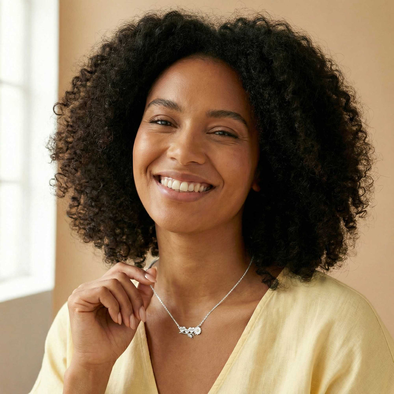 Daisy Name Necklace worn by a smiling woman, showcasing the delicate design with three connected hearts by Brother & Sisters.