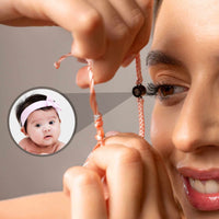 Thumbnail for Close-up of a woman wearing the Pink Photo Bracelet, featuring a personalized photo of a baby, by Brother & Sisters.
