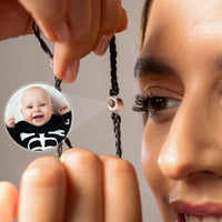 Thumbnail for A woman holding the Black Photo Bracelet featuring a personalized photo of a smiling baby, showcasing its sentimental design by Brother & Sisters.