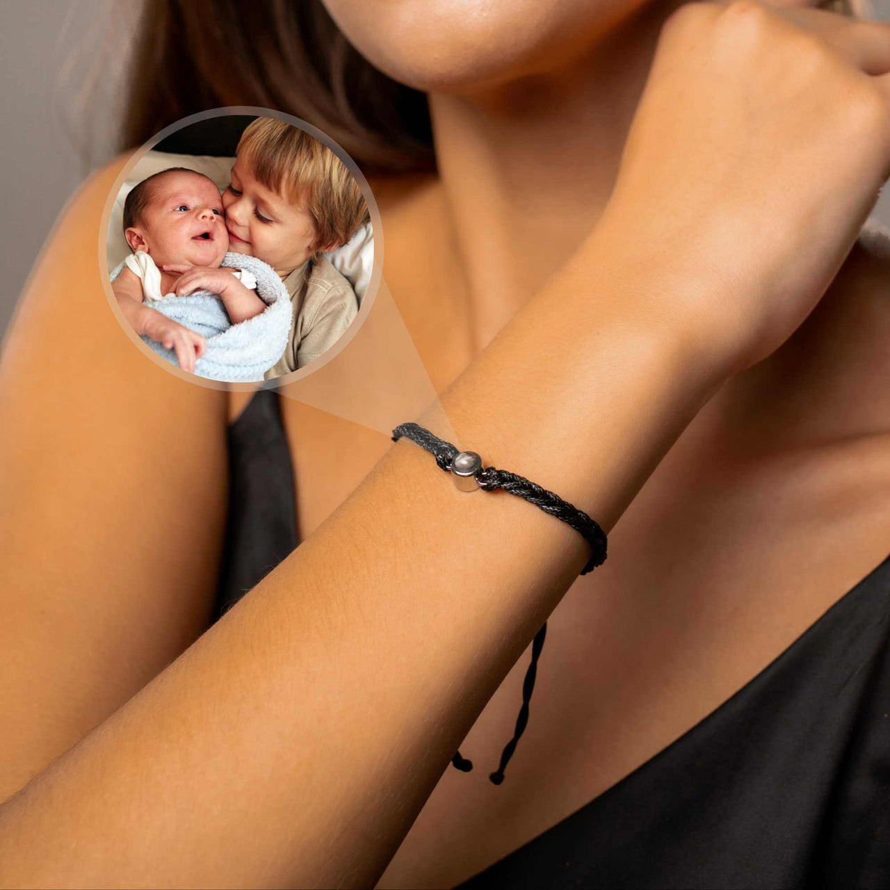 Black Photo Bracelet worn on wrist with circular pendant showcasing a personal photo, by Brother & Sisters.