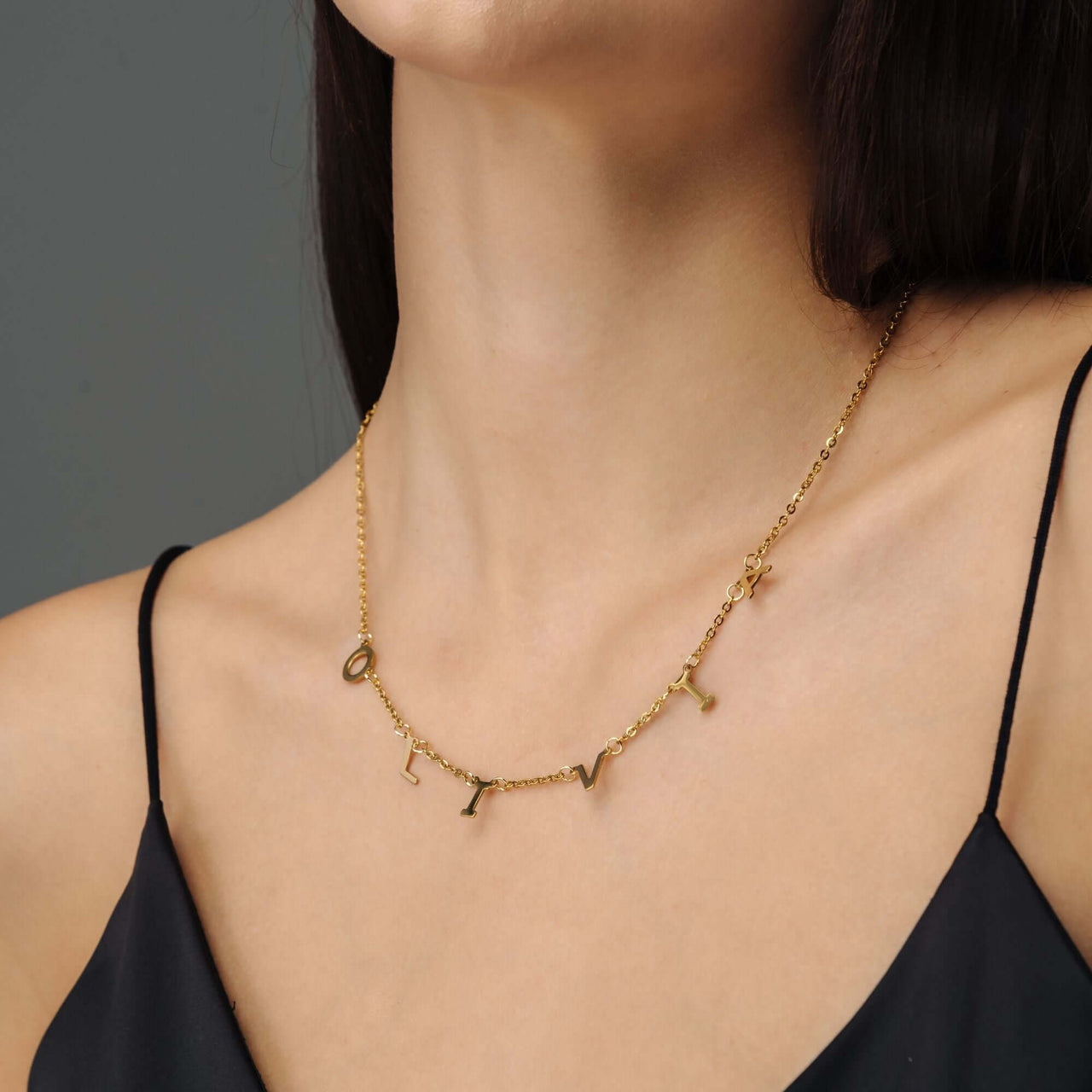 Classic Name Necklace in gold on a model, showcasing personalized letters by Brother & Sisters.