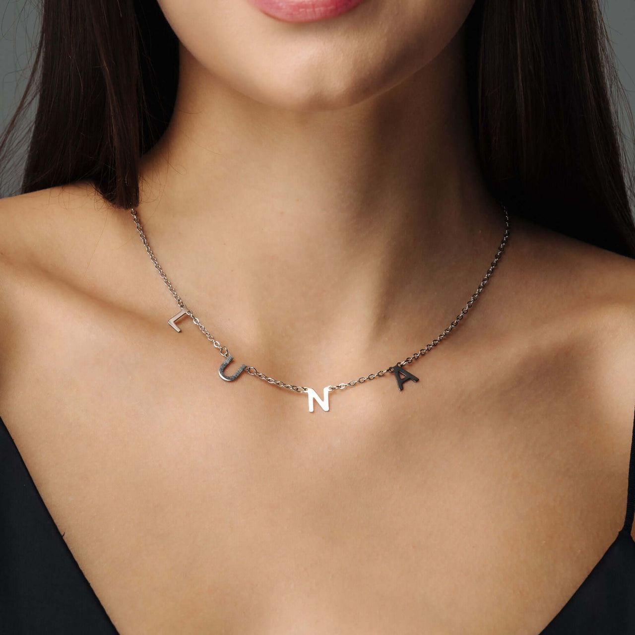 Classic Name Necklace worn by a woman, featuring personalized letters and crafted in high-quality titanium steel by Brother & Sisters.