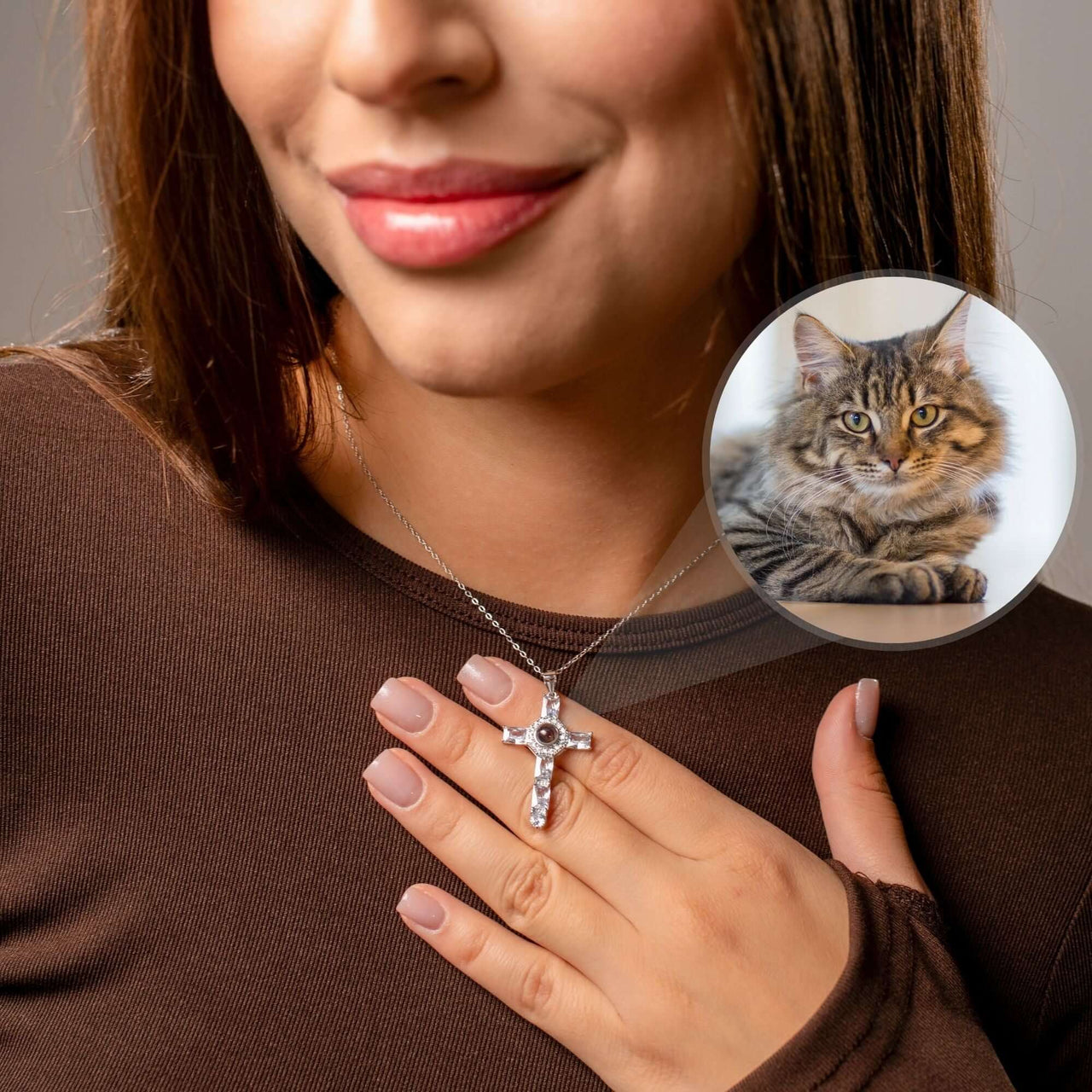Close-up of a woman wearing a Cross Photo Necklace, featuring a cat's photo projection, by Brother & Sisters.