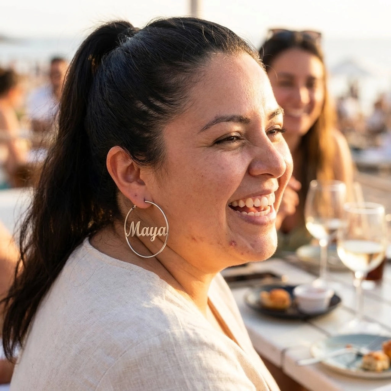 Custom Name Hoop Earrings in Silver worn outdoors, lifestyle shot | SKU: name-hoop-silver-30-mm
