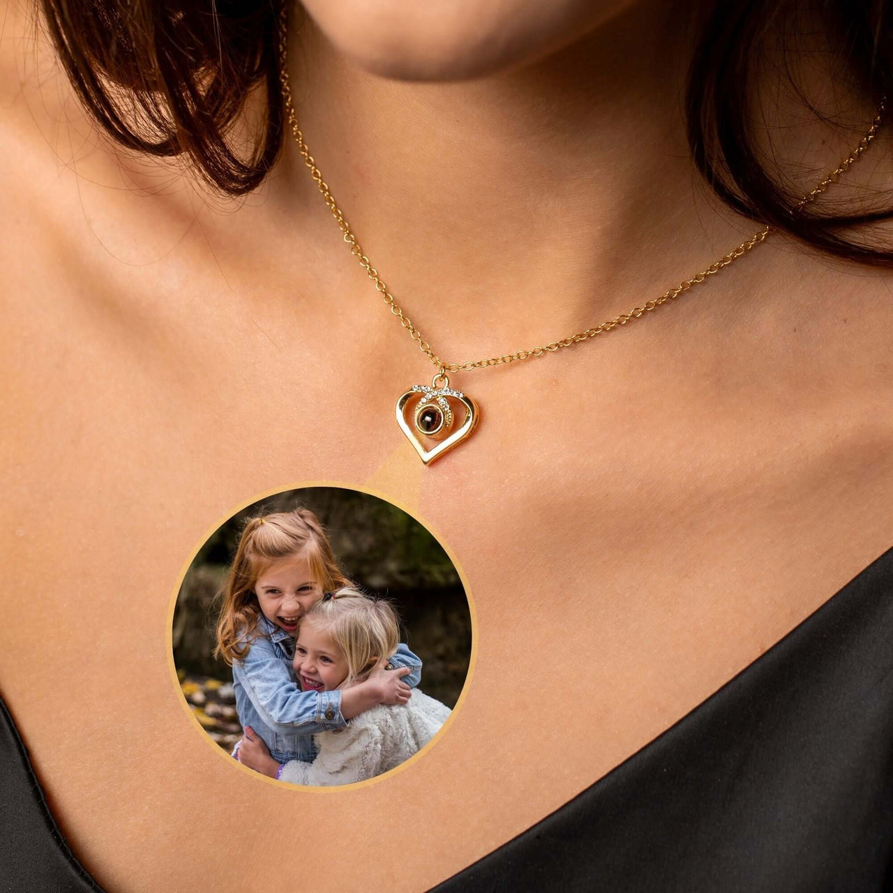 Eternal Photo Necklace by Brother & Sisters featuring a heart charm with a photo projection of two smiling girls.