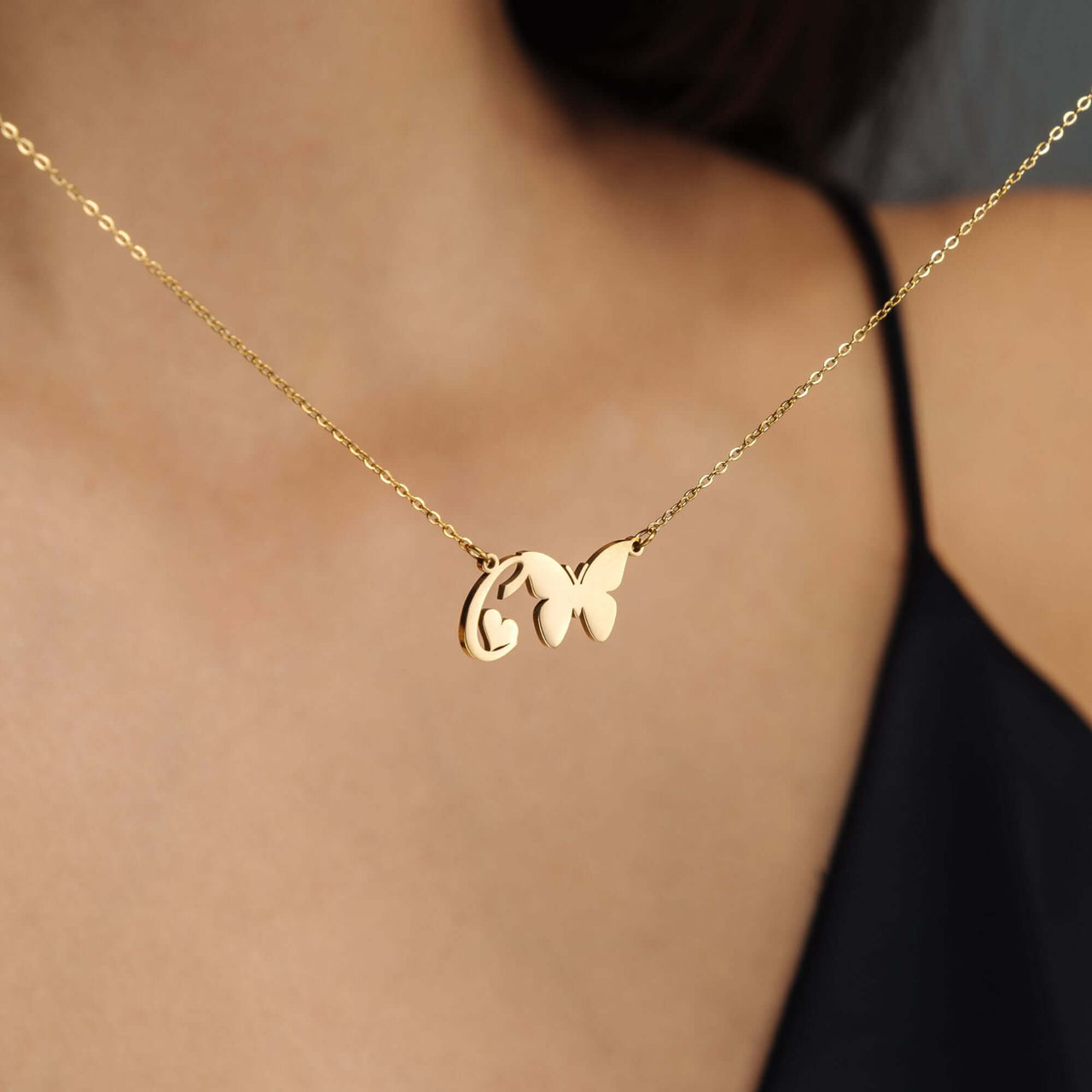 Butterfly Initial Necklace by Brother & Sisters featuring a gold butterfly charm and custom initial pendant.