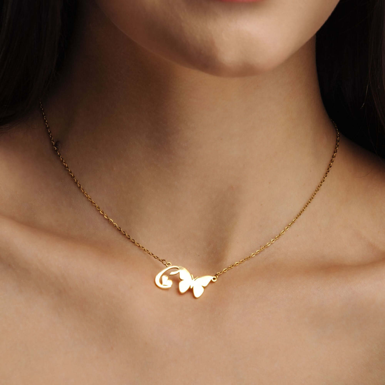 Butterfly Initial Necklace worn by a woman, featuring a delicate butterfly charm and gold chain, by Brother & Sisters.
