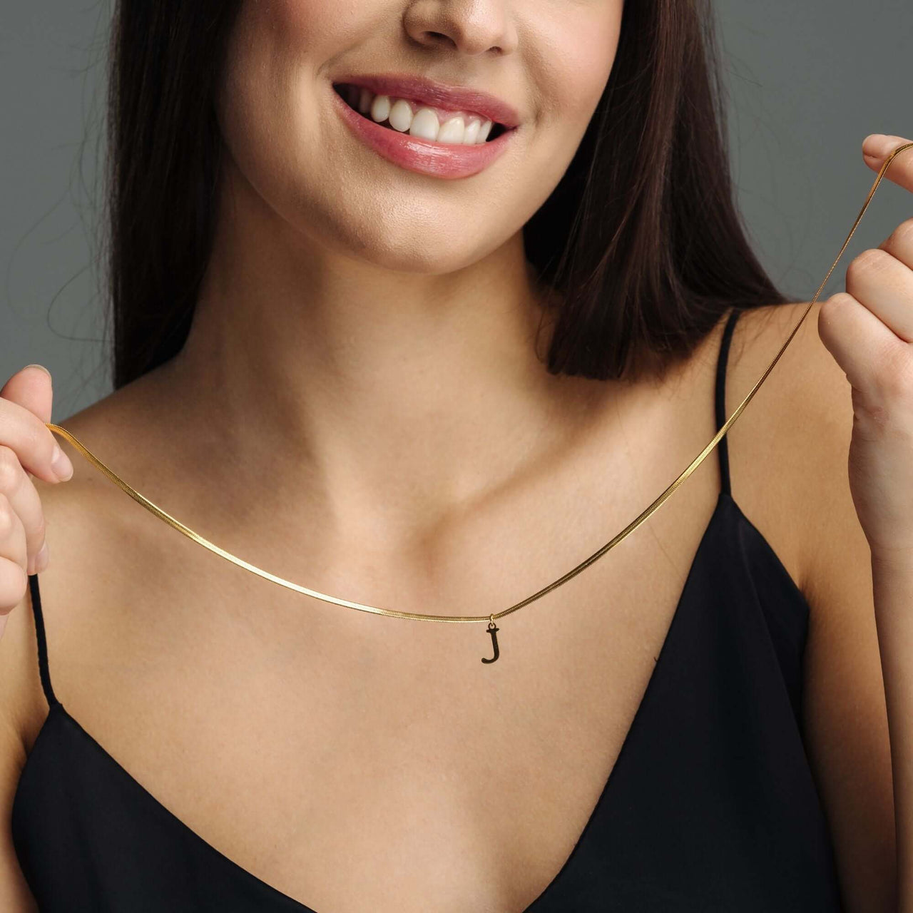 Harmony Initial Necklace worn by a woman, featuring a refined letter pendant in gold, by Brother & Sisters.