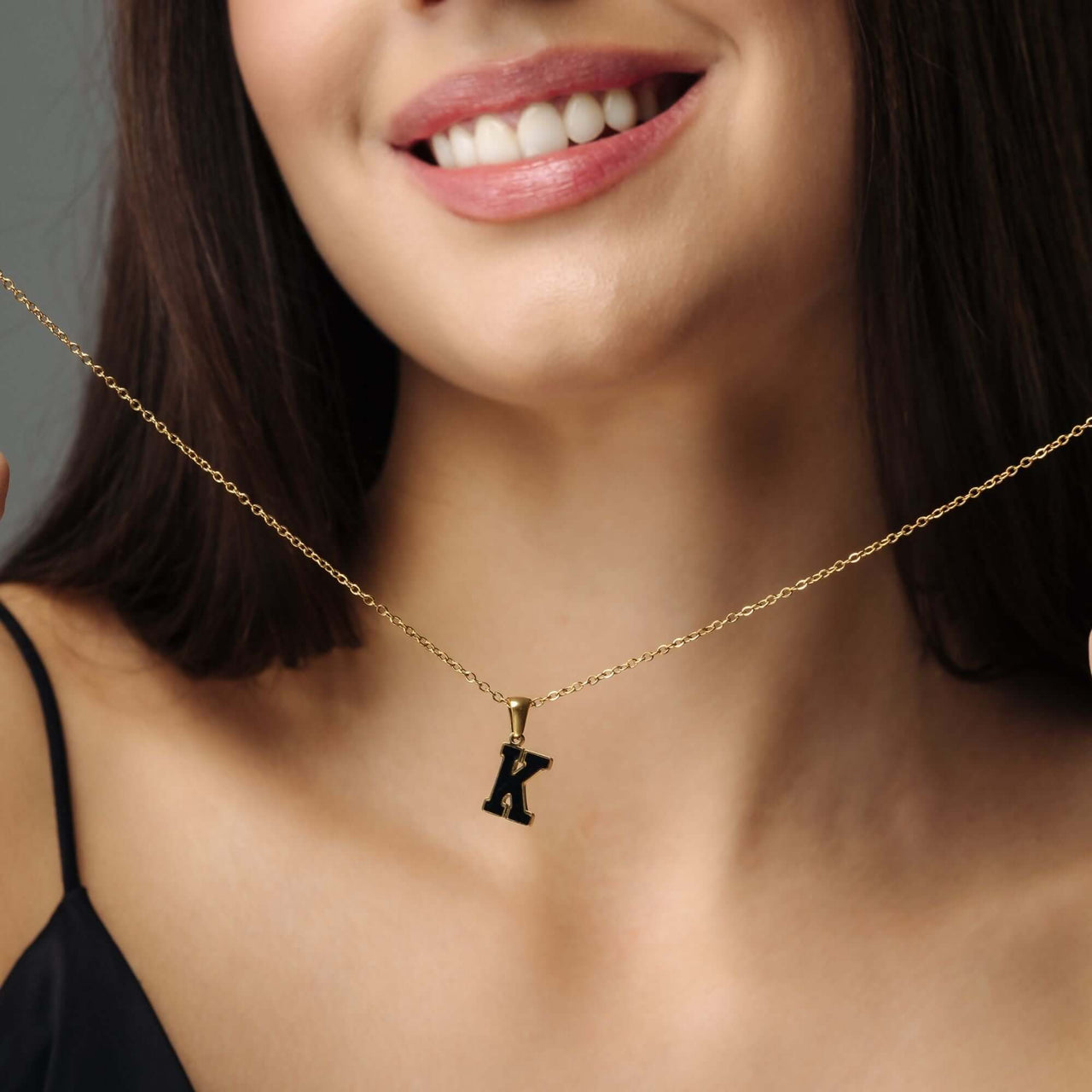 Hope Initial Necklace worn by a woman, featuring a gold letter 'K' pendant, showcasing elegance by Brother & Sisters.