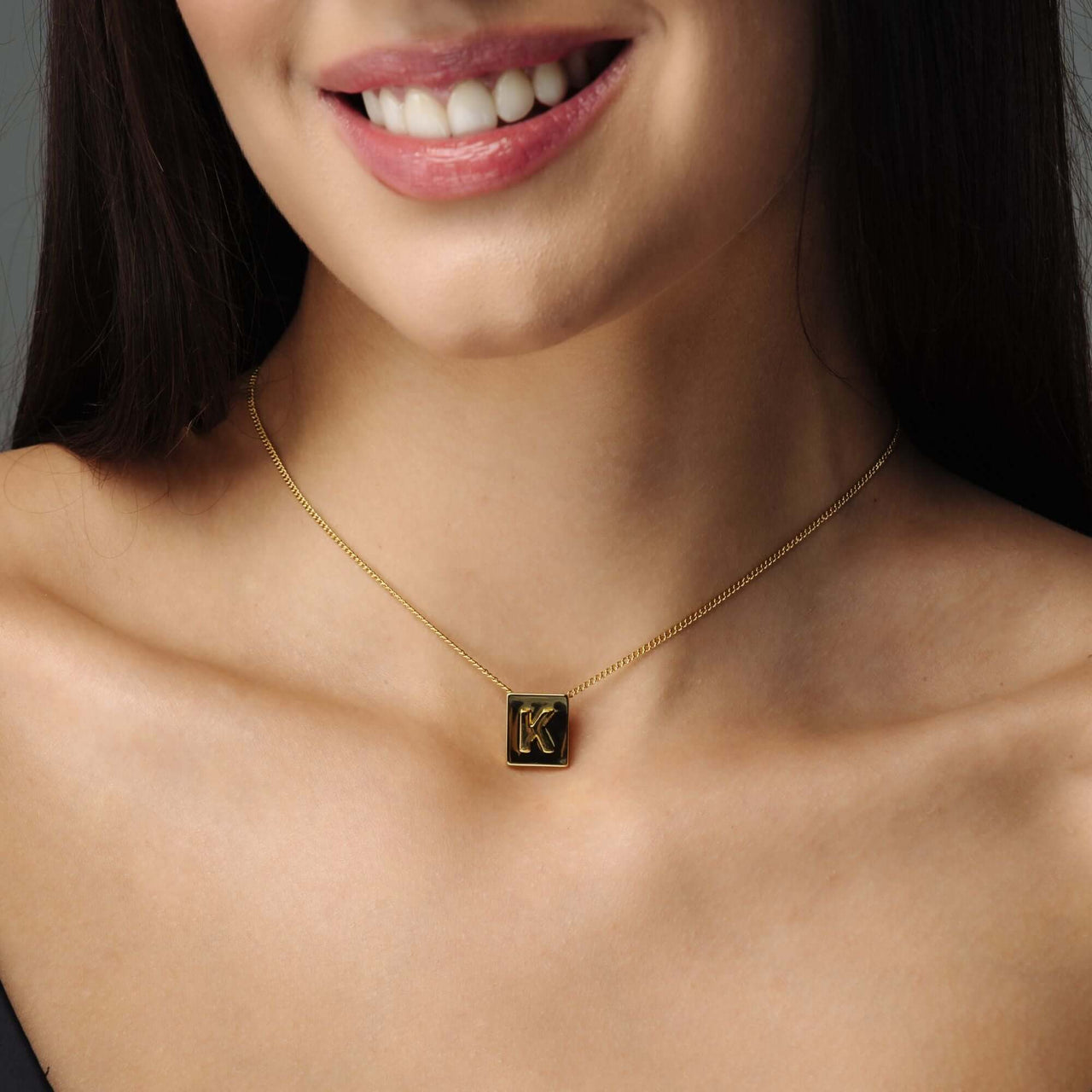 Rectangle Initial Necklace worn by a woman, featuring a minimalist gold design by Brother & Sisters.