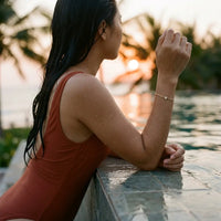 Thumbnail for Vietnamese woman at tropical infinity pool wearing gold Heart Bond bracelet