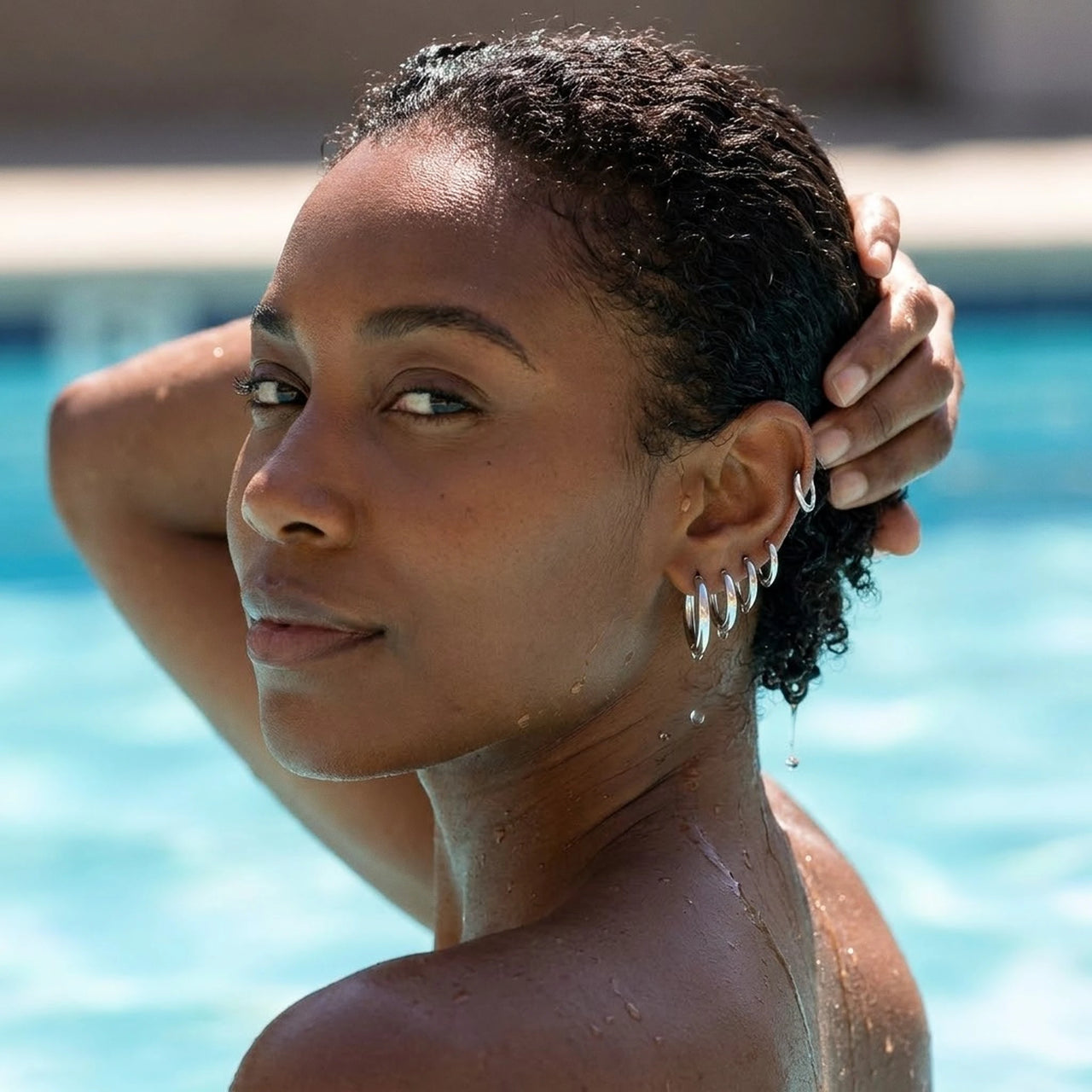 Huggie Hoop Earrings Set of 4 Pairs in Silver worn in a swimming pool, waterproof 304L stainless steel | SKU: huggie-set-silver