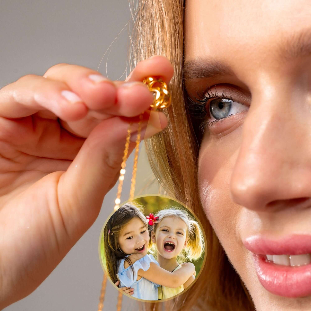 Woman holding the Infinite Photo Necklace by Brother & Sisters, showcasing a cherished photo of two smiling girls.