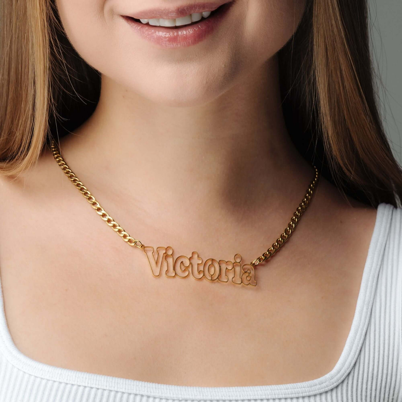 Luxury Name Necklace by Brother & Sisters worn by a model featuring the name Victoria in elegant gold design.