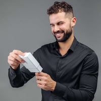 Thumbnail for Man in a black shirt happily unboxing the Minimalist Photo Bracelet by Brother & Sisters.