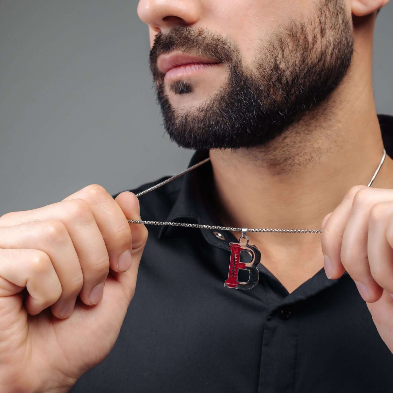 Man wearing Rugby Initial Necklace by Brother & Sisters, showcasing a bold silver letter pendant.