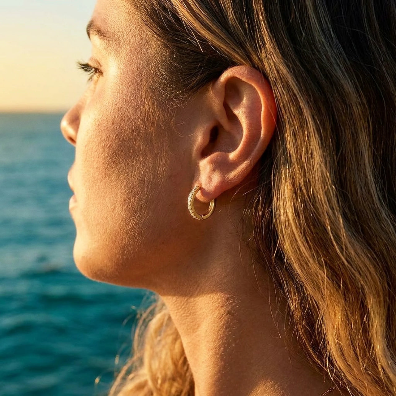 Pave Huggie Hoop Earrings in Gold, close-up on the earlobe | SKU: 41011-gold