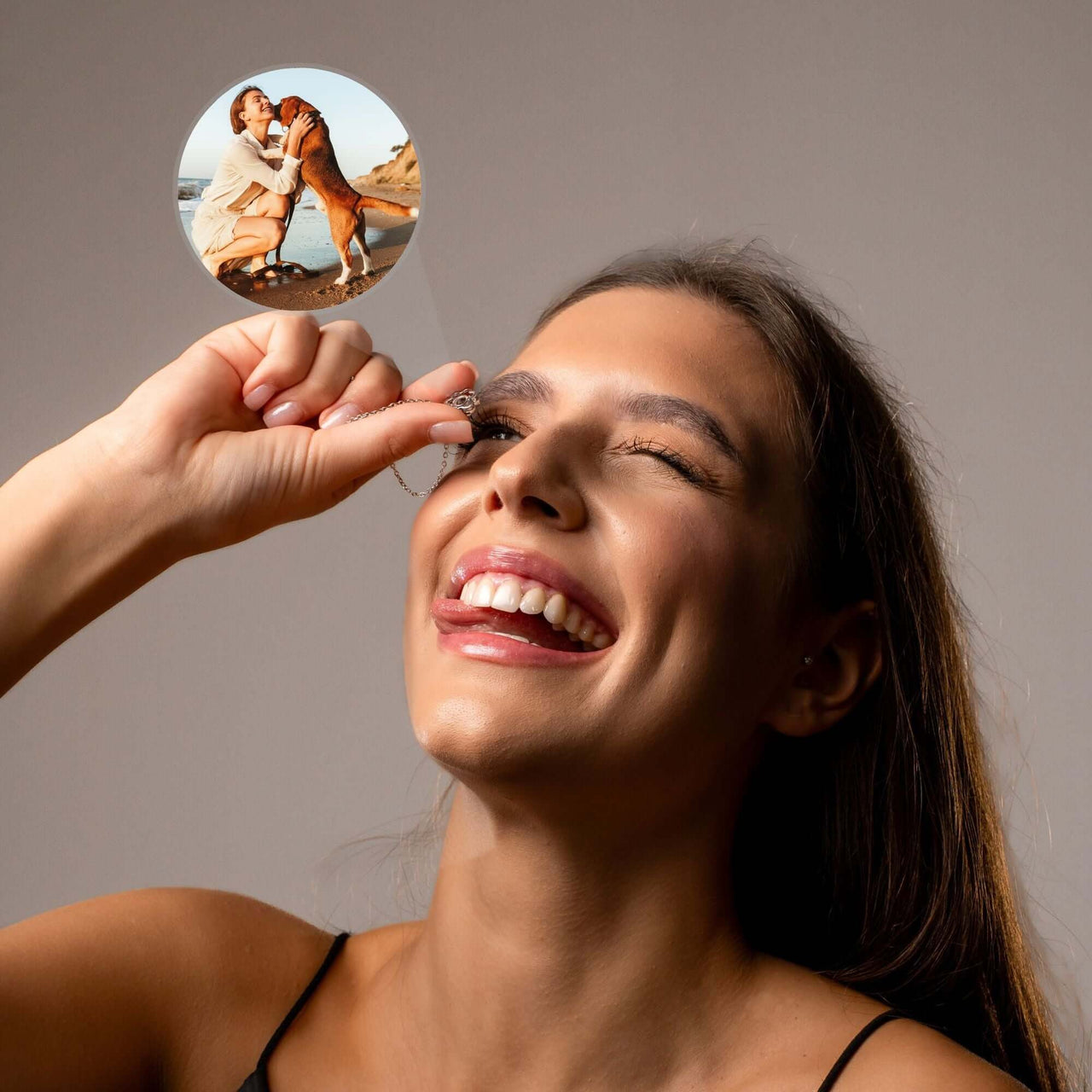 Woman showcasing the Paw Print Photo Necklace, revealing a cherished photo projection of her pet.