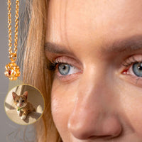 Thumbnail for Close-up of a woman wearing a Paw Print Photo Necklace by Brother & Sisters with a photo projection of her pet.