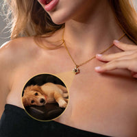 Thumbnail for A woman wearing a Paw Print Photo Necklace by Brother & Sisters, showcasing a projection of her pet.