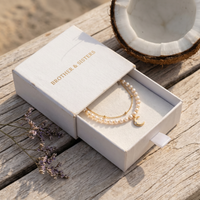 Thumbnail for Brother & Sisters Pearl Moon Anklet Set in box with delicate pearls, crescent moon, and floral accents, embodying luxury.