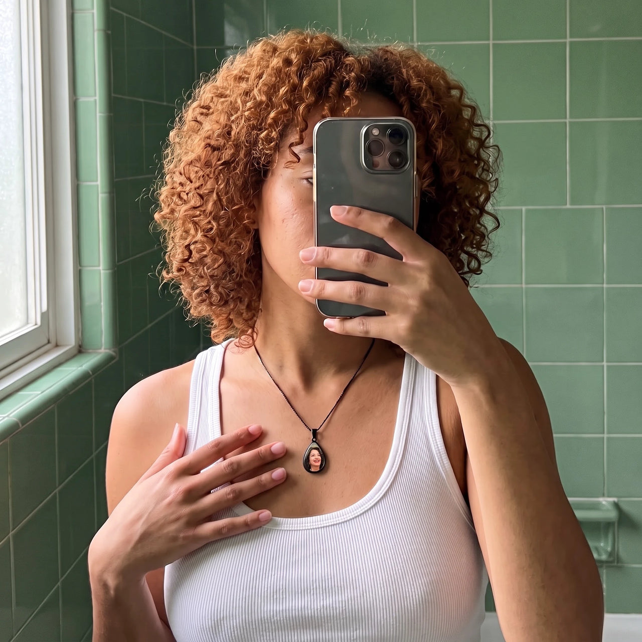 Mirror selfie of a woman with curly red hair wearing the black secret drop photo necklace | SKU: TPH-DRPN-BLACK
