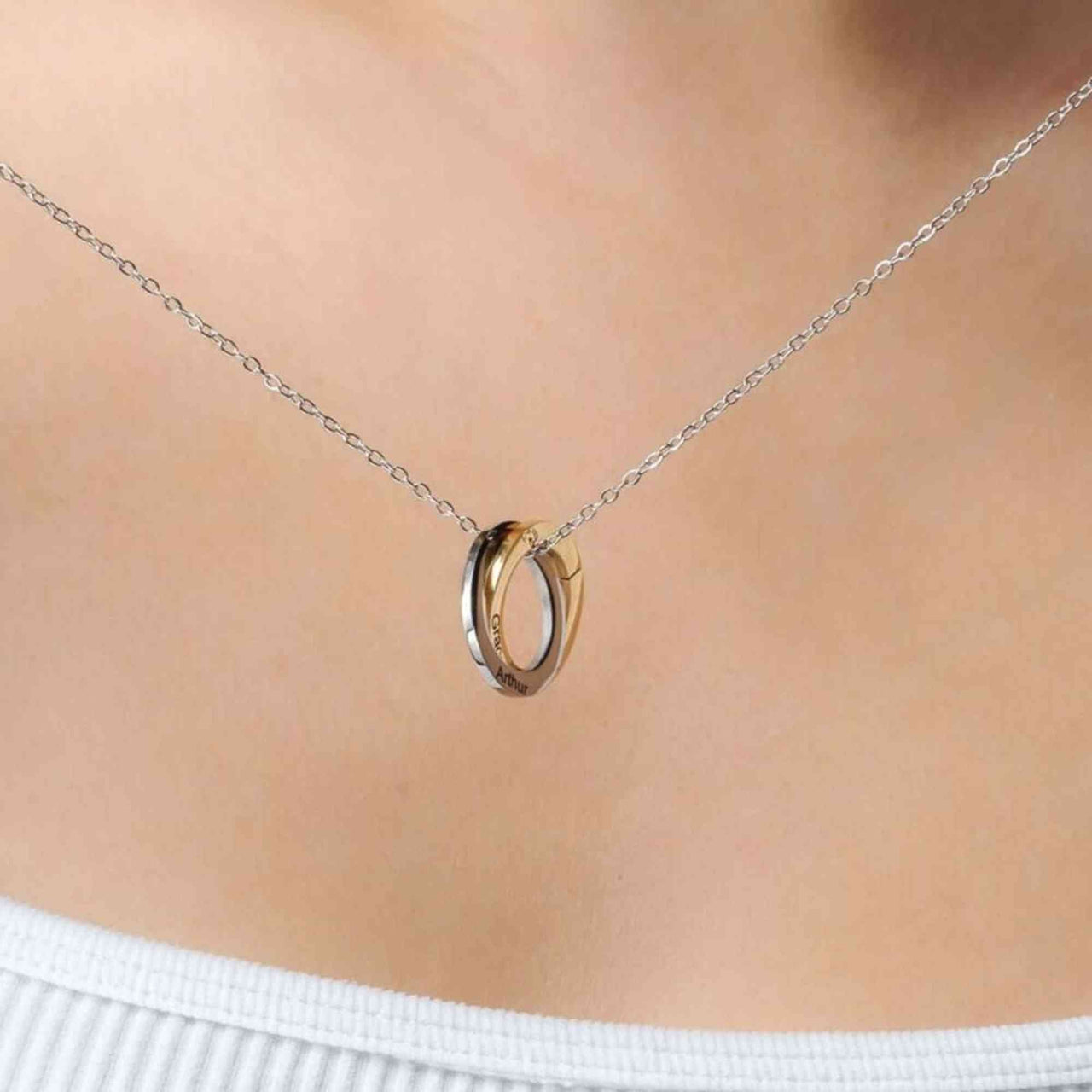 Triple Name Necklace by Brother & Sisters, featuring intertwined gold and silver rings on a delicate chain.